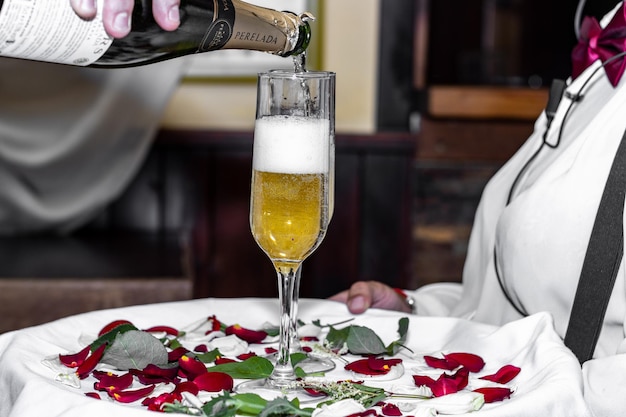 Closeup of hands holding a tray with two glasses of champagne Waiter hands holding tray with two glasses of champagne Unrecognizable person holding tray with two glasses of champagne