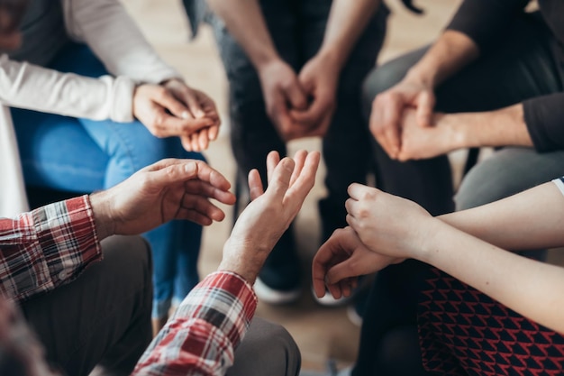 Photo closeup of hands of people sitting in a circle during a therapy group meeting