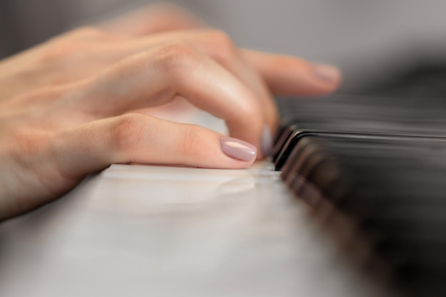 Closeup of hands playing piano music and hobby concept