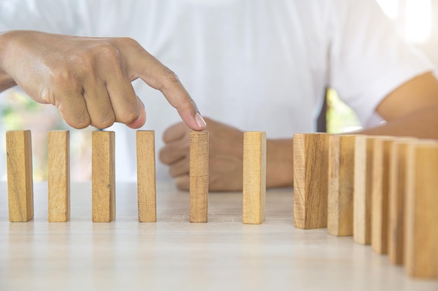 Closeup hands prevent wooden block not falling