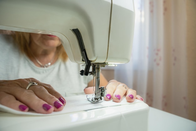 Closeup of the hands of an unrecognizable woman sewing on her sewing machine