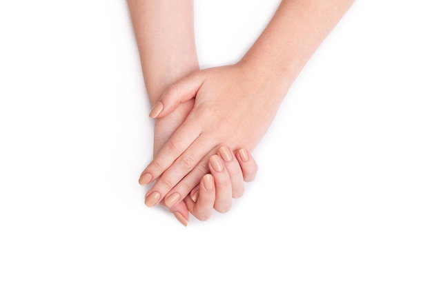 Closeup of hands of a young woman with manicure on nails against white background