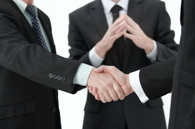 Closeup of handshake of two entrepreneurs wearing business suit, shot against bokeh background