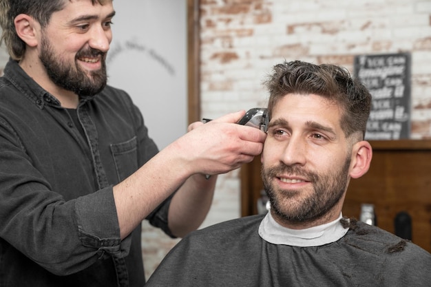 Closeup of happy man getting an haircut in hair salon High quality photo