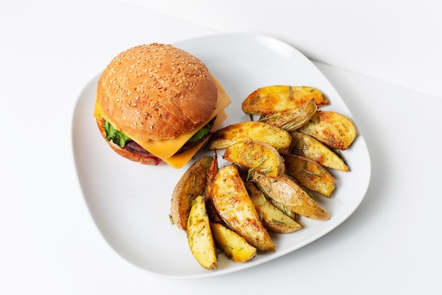 Closeup of homemade vegan cheeseburger and roasted potatoes with rosemary