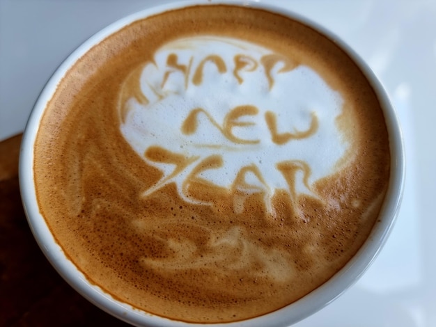 Closeup of hot latte art word coffee (happy new year)