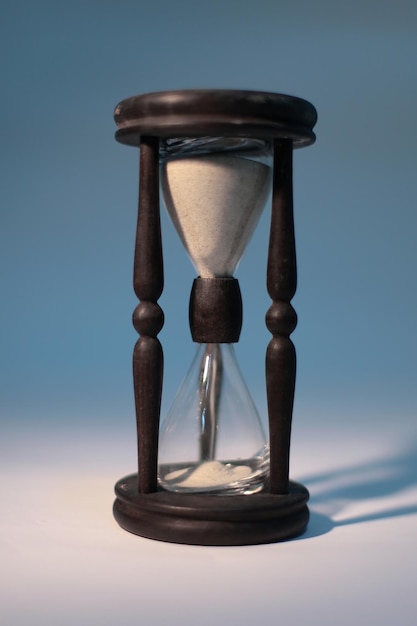 Closeup of hourglass isolated on blue background