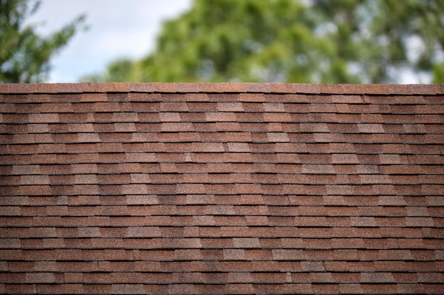 Closeup of house roof top covered with asphalt or bitumen shingles Waterproofing of new building