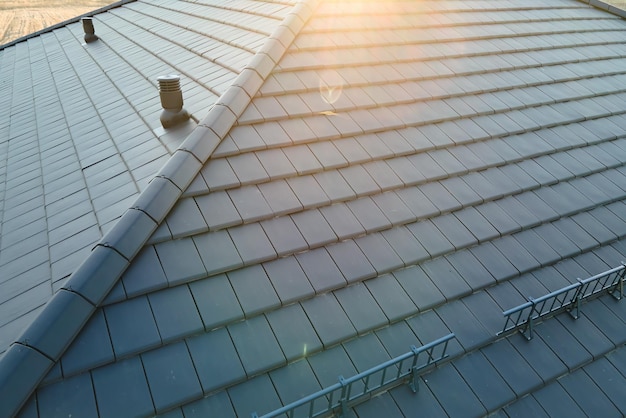 Closeup of house roof top covered with ceramic shingles Tiled covering of building