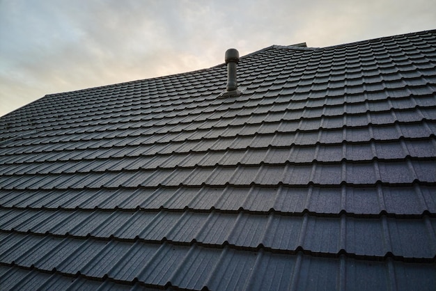 Closeup of house roof top covered with metallic shinglesTiled covering of building