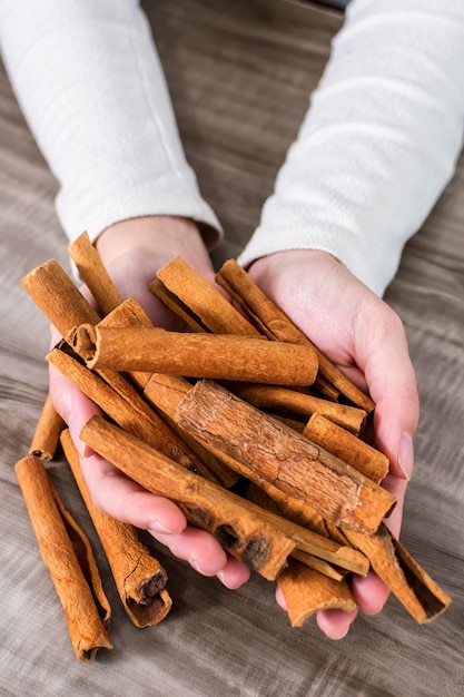 Closeup Of Human Hand Holding Cinnamon Sticks