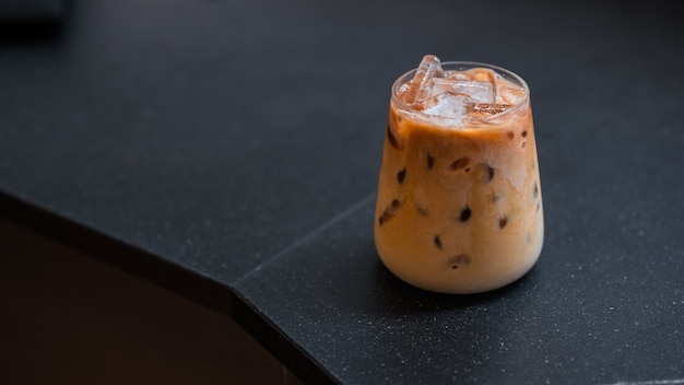 Closeup of iced coffee served on black table at cafe