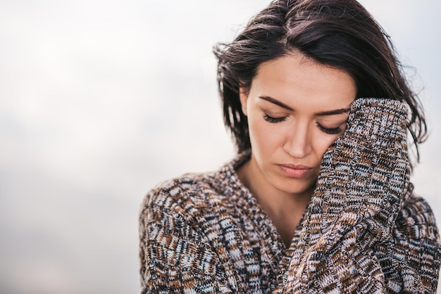 Closeup image of beautiful dreamy female posing against lake with blowing hair Portrait of romantic female closed eyes enjoying the meditation Background mood concept People lifestyle and travel