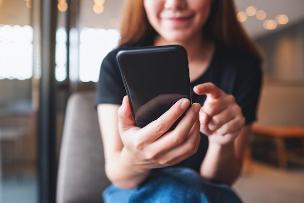 Closeup image of a beautiful young asian woman holding and using mobile phone