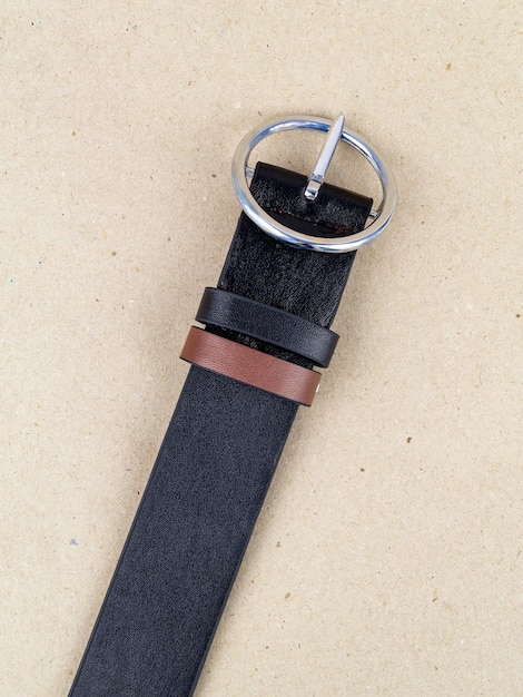 A closeup image of a belt for trousers and a skirt on a paper background