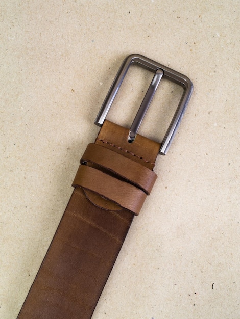 A closeup image of a belt for trousers and a skirt on a paper background