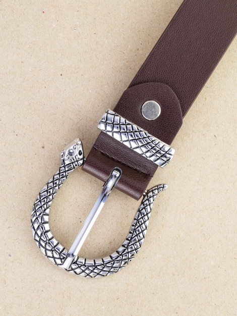 A closeup image of a belt for trousers and a skirt on a paper background