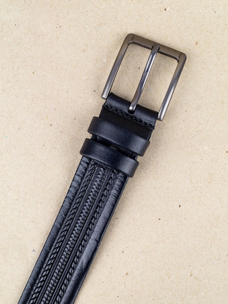 A closeup image of a belt for trousers and a skirt on a paper background