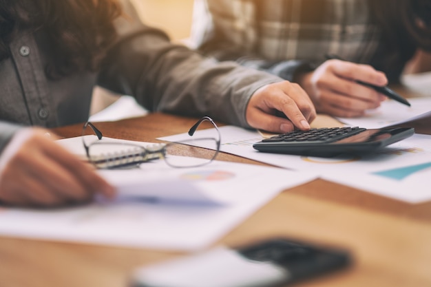 Closeup image of a businessman using calculator in a business meeting