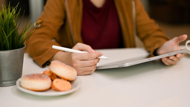 Closeup image Female freelancer of college student remote working at the cafe using digital tablet