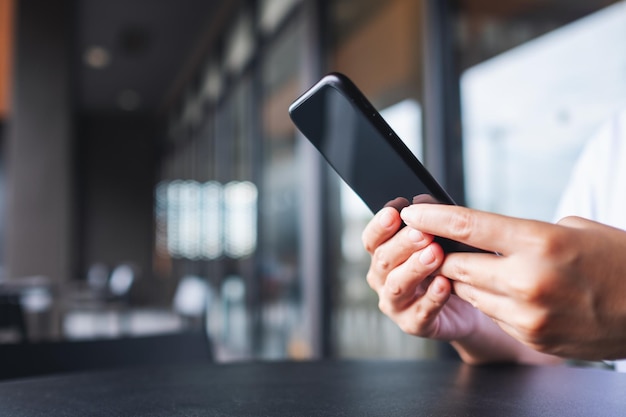 Closeup image of hands holding and using mobile phone