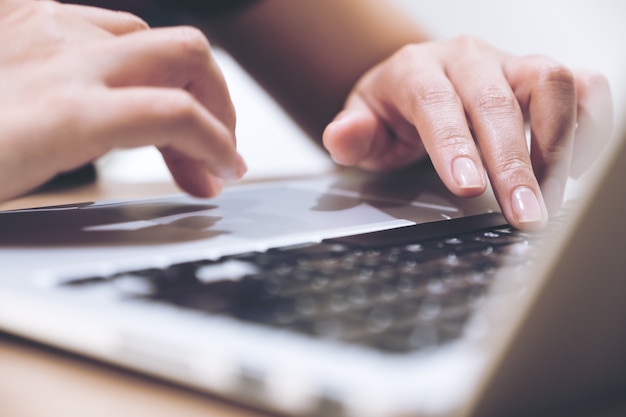 Closeup image of hands working and typing on laptop keyboard 