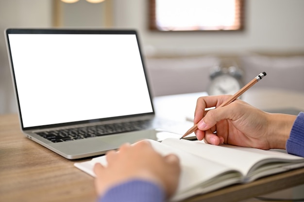 Closeup image of a male student doing homework laptop white screen mockup