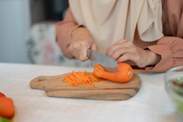 Closeup image of a Muslim woman is preparing ingredients for her salad mix in a kitchen