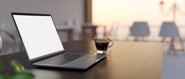 Closeup image Notebook laptop mockup on modern dark working table in cafe coworking space