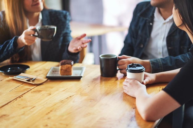 Closeup image of people enjoyed talking and drinking coffee together in cafe