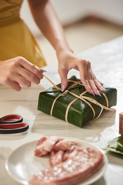 Closeup image of woman cooking sticky rice cakes for friends and relatives