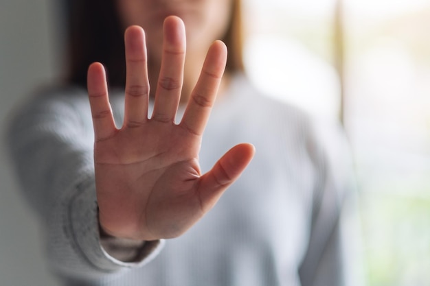 Closeup image of a woman outstretched hand and showing stop hand sign