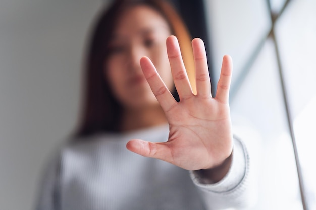 Closeup image of a woman outstretched hand and showing stop hand sign