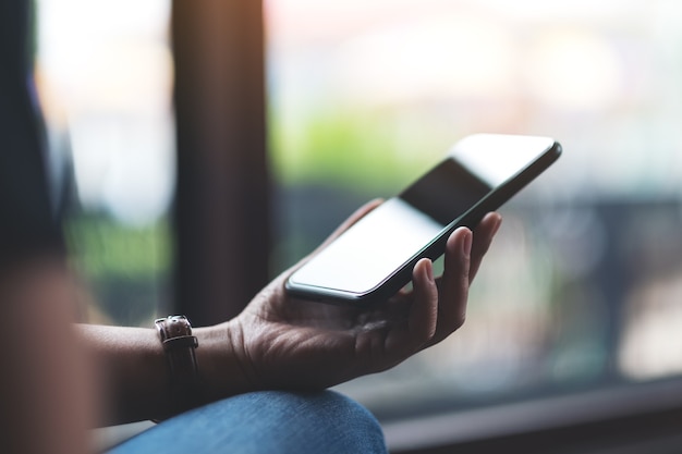 Closeup image of a woman's hands holding and using mobile phone