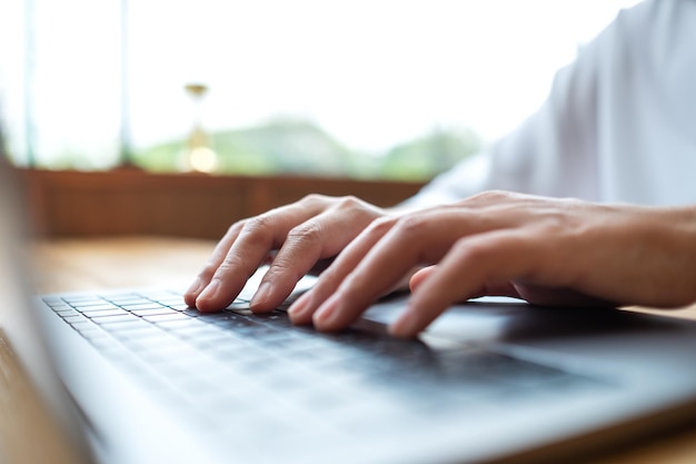 Photo closeup image of a woman working and typing on laptop computer keyboard