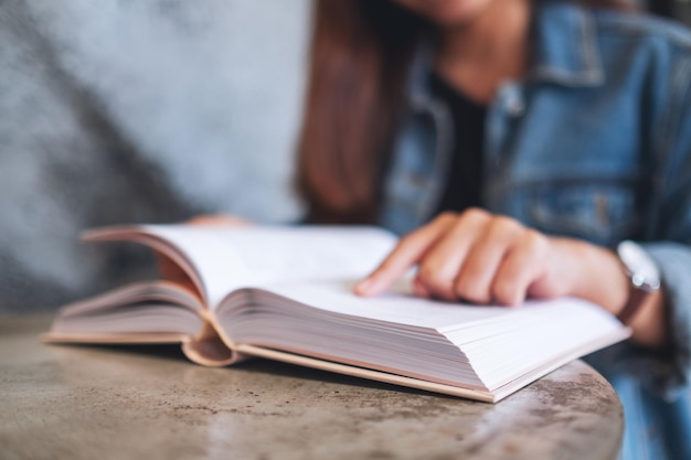 Closeup image of a young woman sitting and reading book