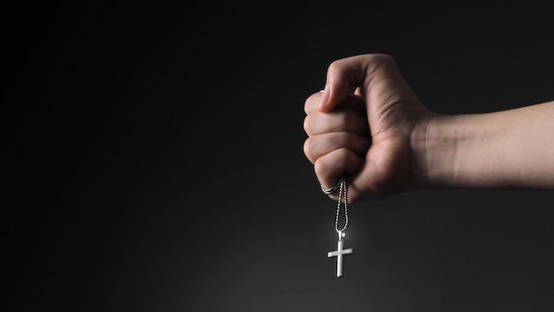 Closeup images of crucifix pendant and necklace in hand