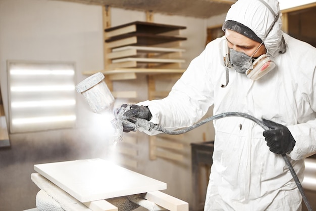 Closeup of industrial worker using paint gun or spray gun for applying paint Application of flame retardant ensuring fire protection airless spraying