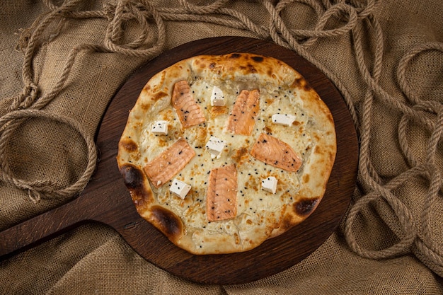 Closeup of an italian pizza with prosciutto ham green olives and rucola