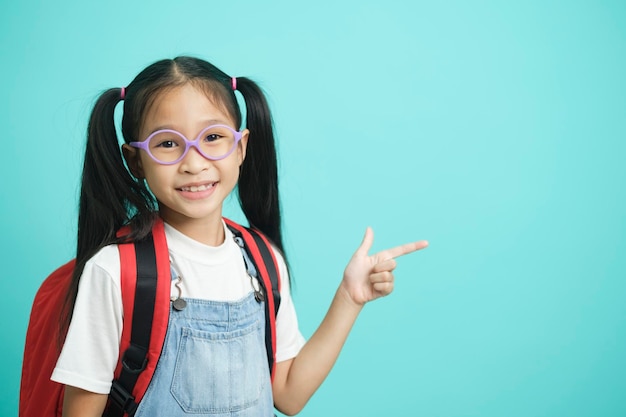 Closeup kid schoolgirl Pointing Fingers At Copy Space