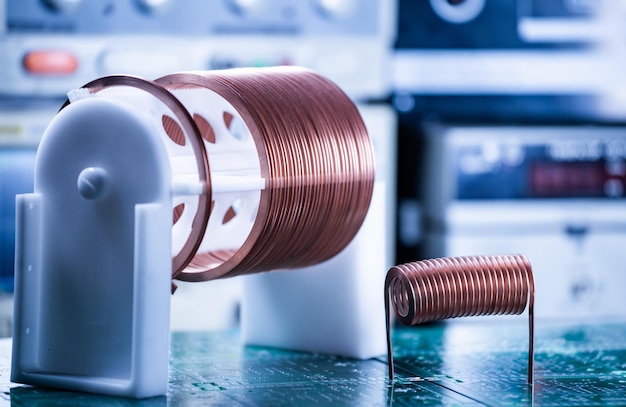 Closeup large and small coils with copper wire stand on a green microcircuit at a factory of classified military equipment Super secret highfrequency components and equipment concept