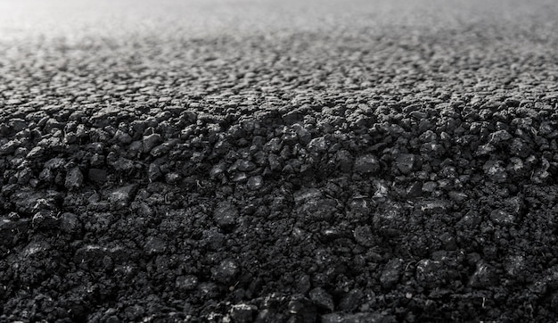 Photo closeup on a layer of new asphalt at the road under construction