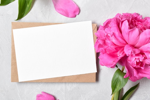 The closeup layout is made of a kraft envelope and the color of a peony on a gray background minimalism Space for copying Flat position top view