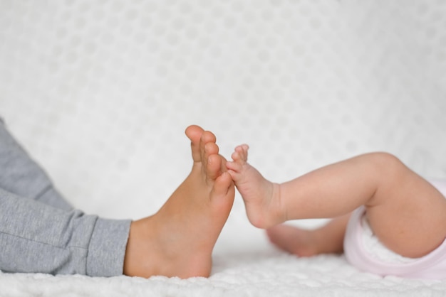 Closeup of the legs of two little brother and sister touching each other Family relations child