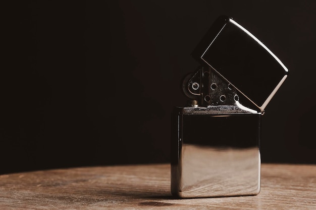 closeup of a lighter on a wood table with black bacground