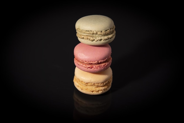 Closeup of macarins of various colours on a black background