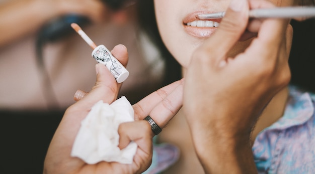 Closeup makeup artist applying lipstick