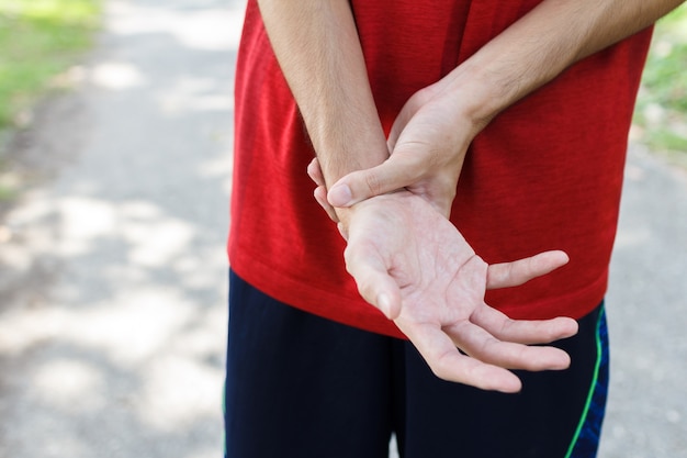 Closeup of male arms holding her painful wrist because exercise