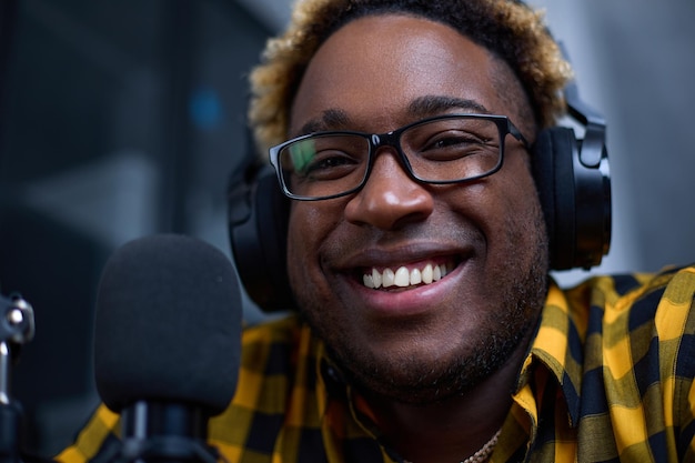 Closeup of a male blogger speaking into a microphone recording a podcast