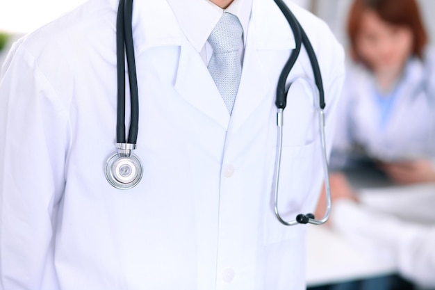 Closeup of a male doctor in a background of doctor and patient